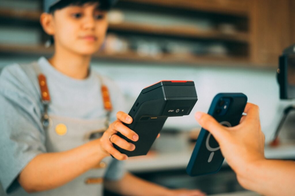 Paying at a counter with a smartphone held up to a card reader